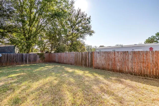 a view of a backyard with wooden fence