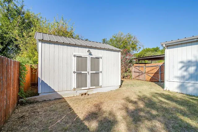 a view of a house with backyard and wooden fence