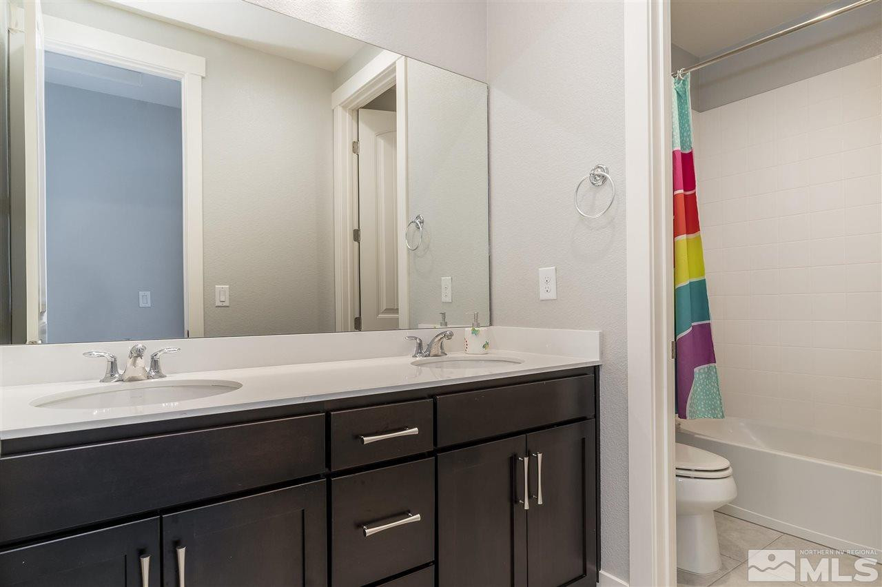 9272 Red Spring Drive Reno, NV 89521 - Photo 14 of 25 a bathroom with a granite countertop sink a toilet and a mirror