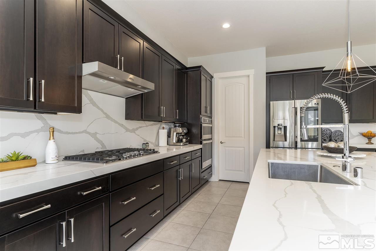 9272 Red Spring Drive Reno, NV 89521 - Photo 7 of 25 a large kitchen with stainless steel appliances kitchen island granite countertop a sink and cabinets