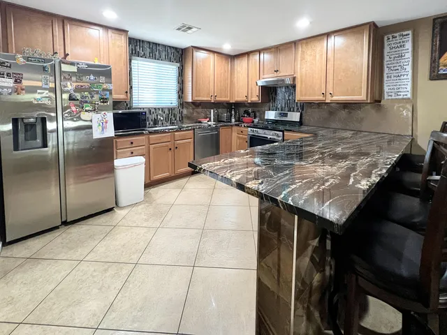 a kitchen with stainless steel appliances granite countertop a sink stove and cabinets