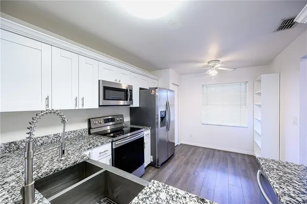 a kitchen with granite countertop a stove and a refrigerator