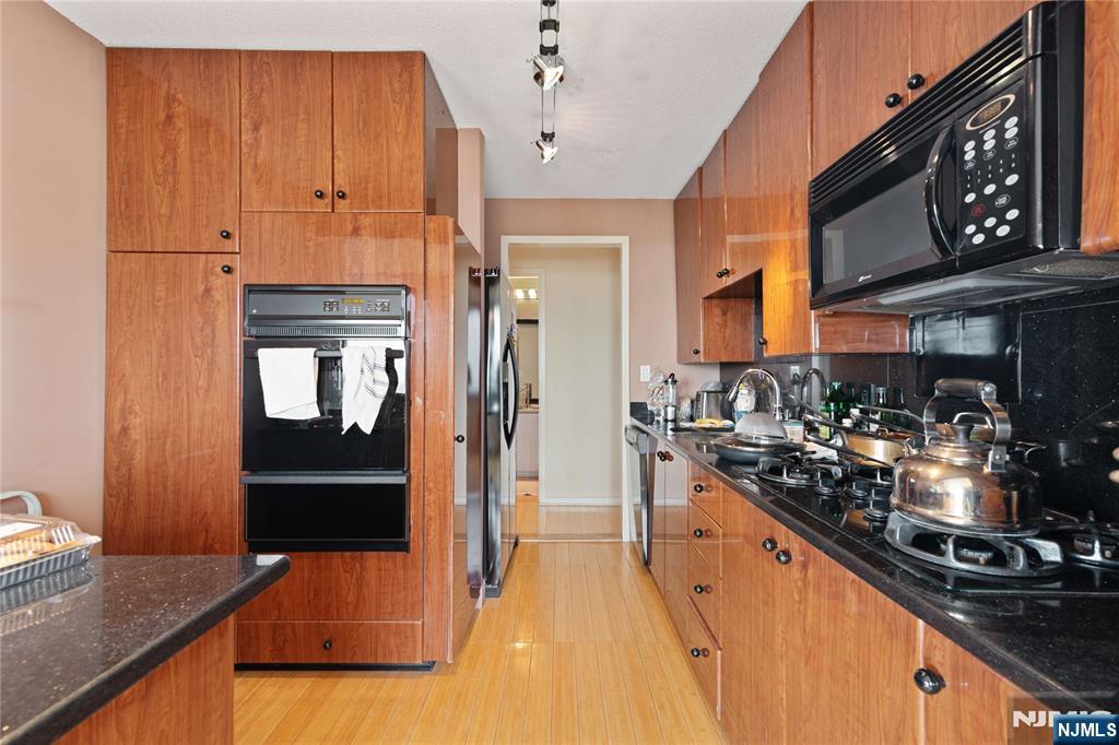200 Old Palisade Road, Unit 21J Fort Lee, NJ 07024 - Photo 11 of 29 a kitchen with stainless steel appliances granite countertop a refrigerator and a stove top oven
