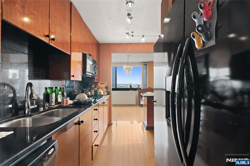 200 Old Palisade Road, Unit 21J Fort Lee, NJ 07024 - Photo 12 of 29 a kitchen with stainless steel appliances a sink a stove and a refrigerator