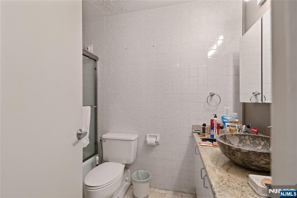 200 Old Palisade Road, Unit 21J Fort Lee, NJ 07024 - Photo 13 of 29 a bathroom with a granite countertop sink mirror vanity and toilet