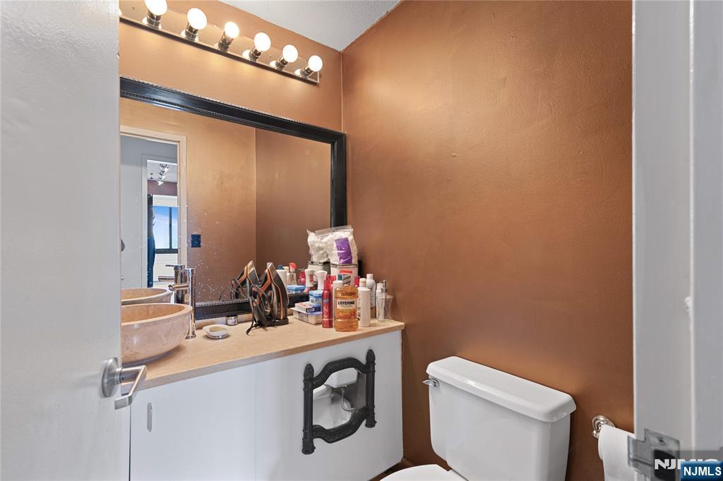 200 Old Palisade Road, Unit 21J Fort Lee, NJ 07024 - Photo 17 of 29 a bathroom with a sink vanity mirror and toilet