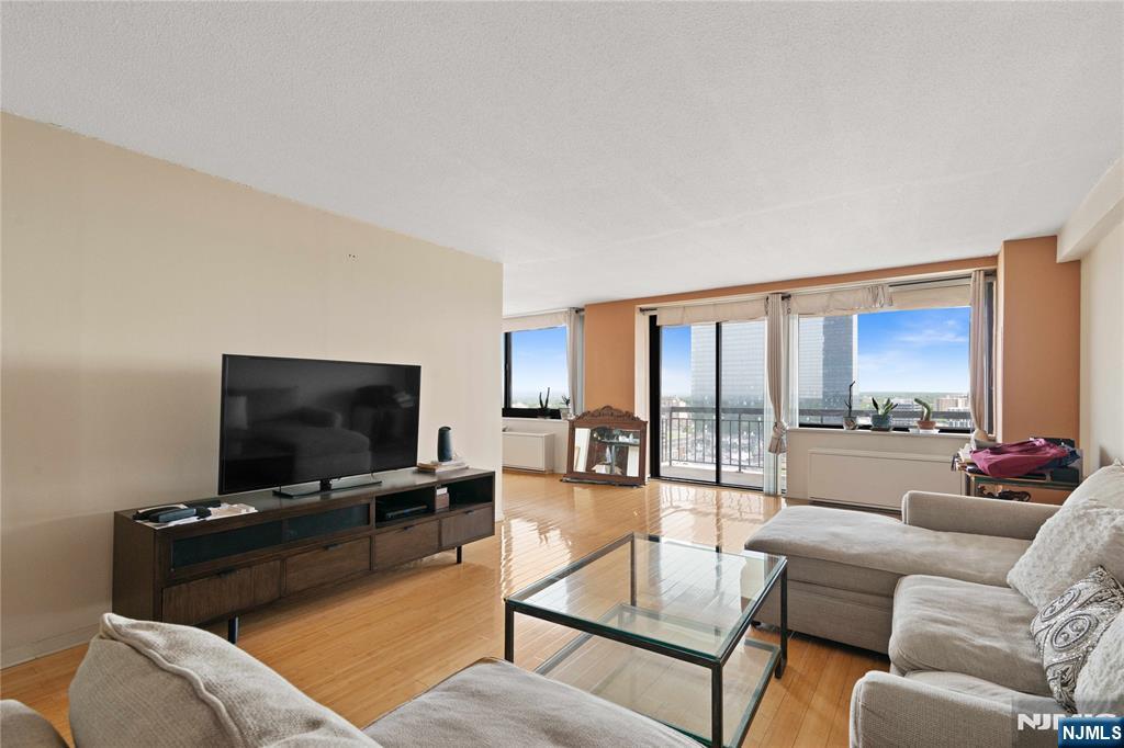 200 Old Palisade Road, Unit 21J Fort Lee, NJ 07024 - Photo 6 of 29 a living room with furniture and a flat screen tv