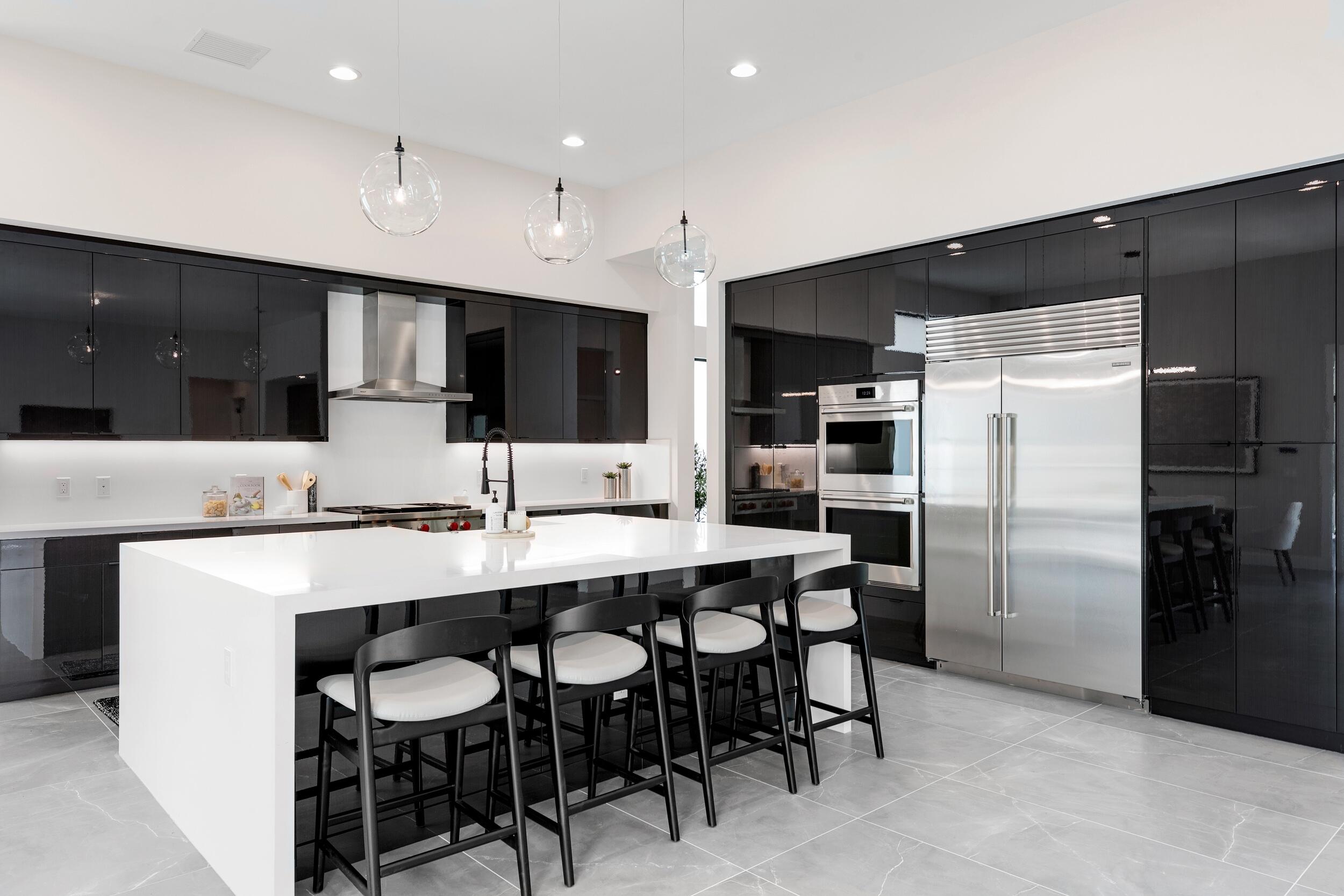 9132 Benedetta Place Boca Raton, FL 33496 - Photo 11 of 50 a kitchen with stainless steel appliances a sink counter space and chairs