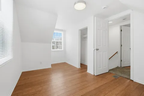 a view of a room with wooden floor and white walls
