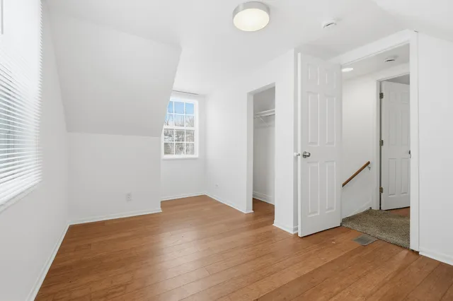 a view of a room with wooden floor and white walls