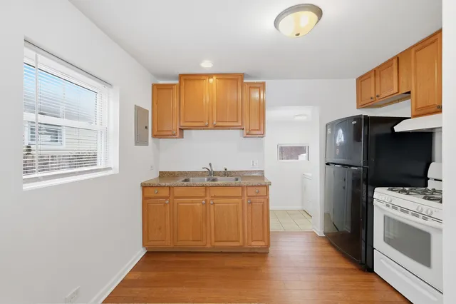 a kitchen with stainless steel appliances granite countertop a refrigerator a stove and a sink