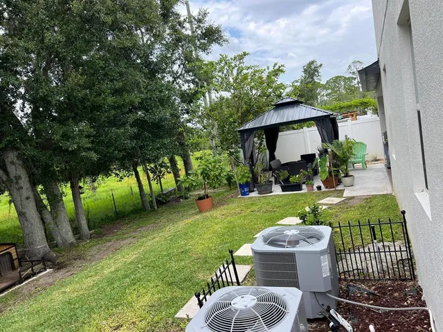 a view of a chair and table in backyard of the house