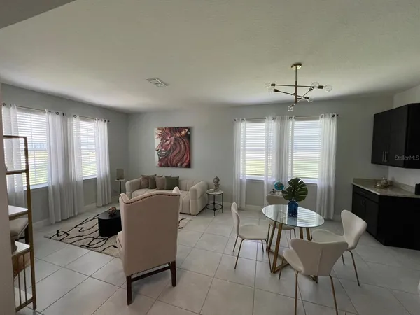 a living room with furniture a flat screen tv and windows