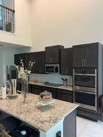 a kitchen with kitchen island granite countertop a refrigerator and a stove top oven