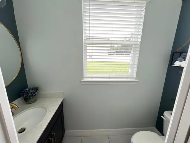 a bathroom with a sink toilet and window