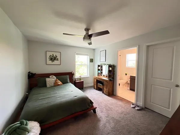 a bedroom with a bed a dresser and a chandelier