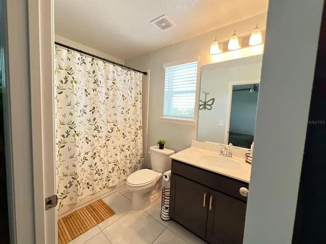 a bathroom with a sink a toilet a shower and a mirror