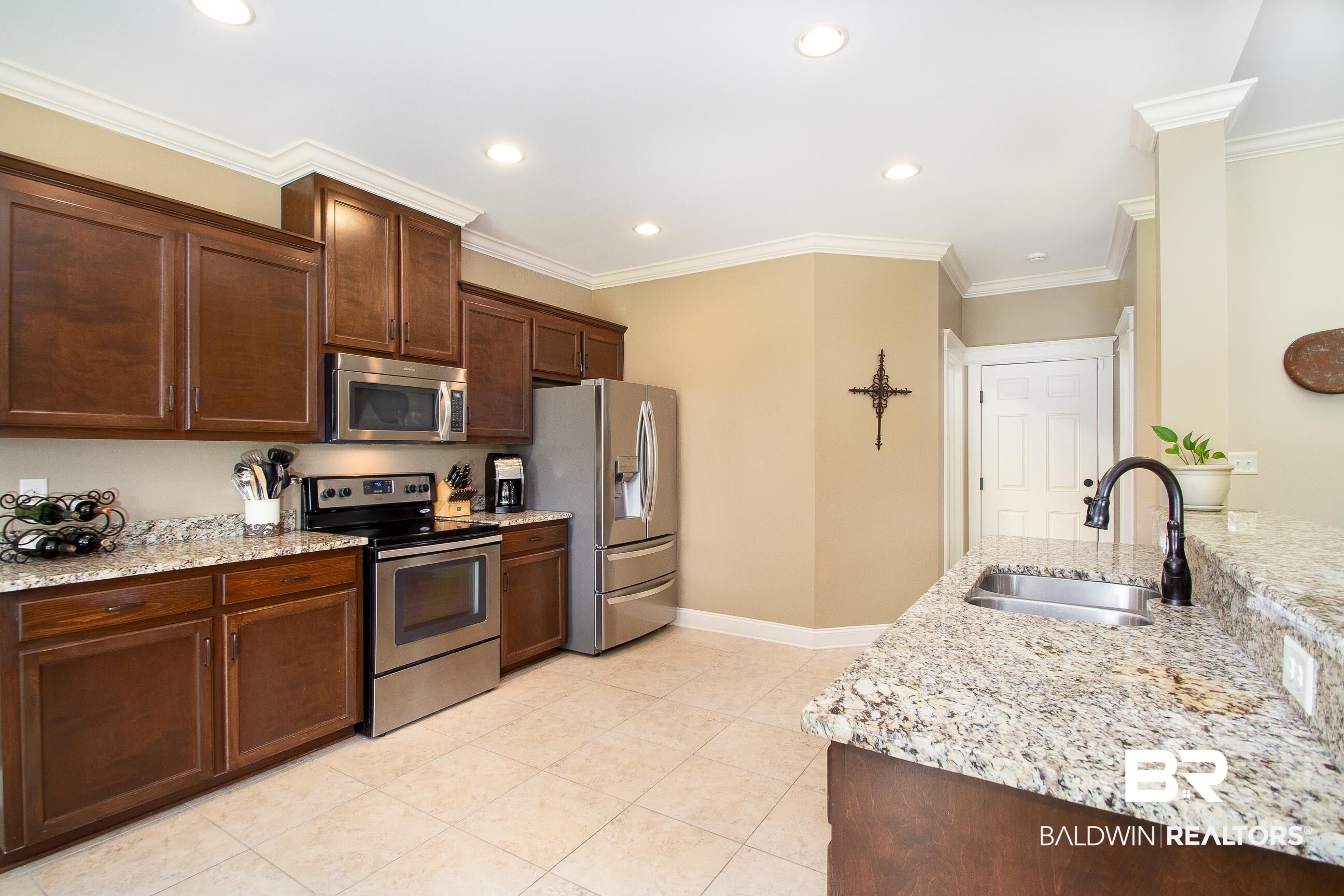 8625 Rosedown Lane Daphne, AL 36526 - Photo 9 of 29 Kitchen with light stone countertops, stainless steel appliances, crown molding, and sink