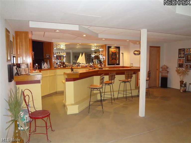 7680 Valley View Road Hudson, OH 44236 - Photo 21 of 25 This is a view of custom built bar from the seating area of the lower level. There is a storage area at the base of the stairs as you come down.