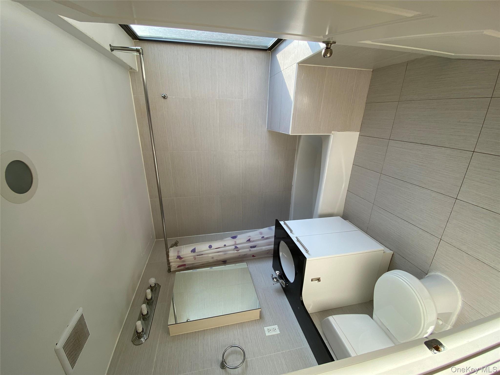 132-35 41st Road, Unit 10D Queens, NY 11355 - Photo 14 of 18 a bathroom with a toilet sink and tub