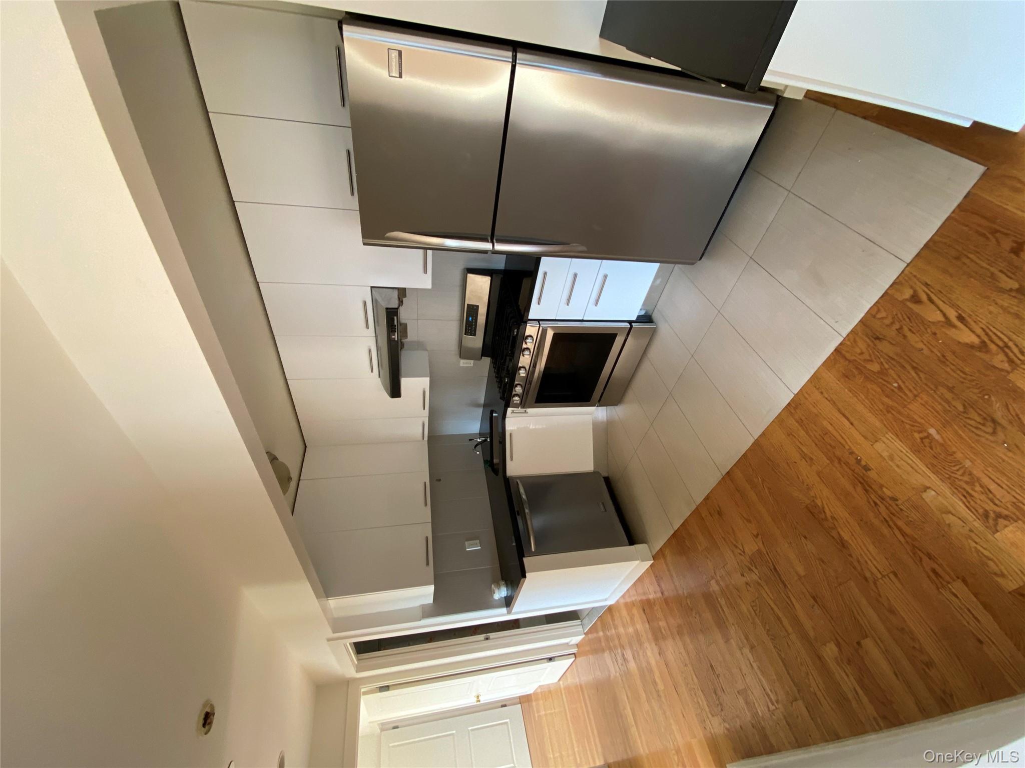 132-35 41st Road, Unit 10D Queens, NY 11355 - Photo 16 of 18 a kitchen with stainless steel appliances granite countertop a refrigerator a stove a sink dishwasher and a refrigerator