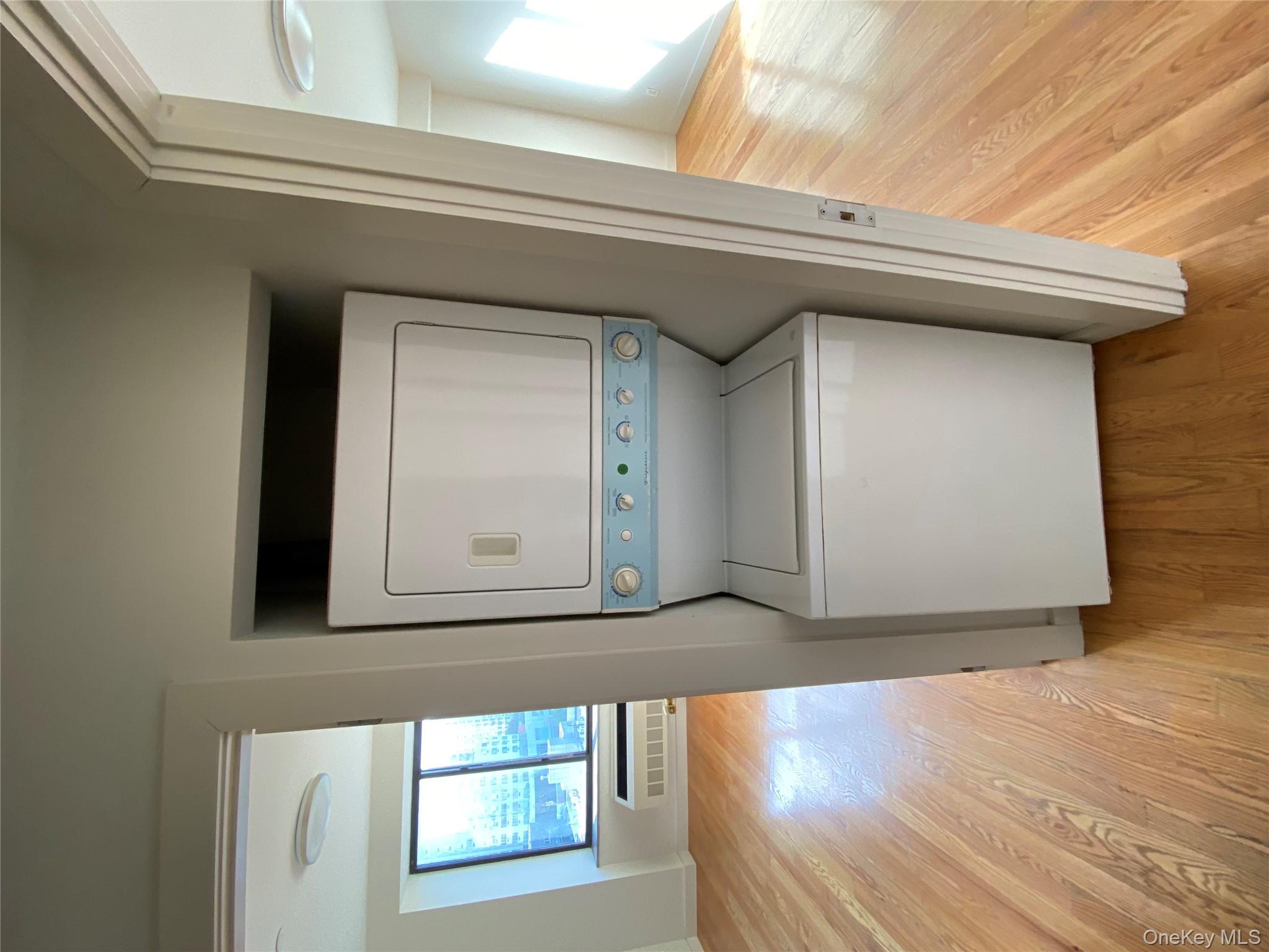 132-35 41st Road, Unit 10D Queens, NY 11355 - Photo 17 of 18 a utility room with wooden floor washer and dryer