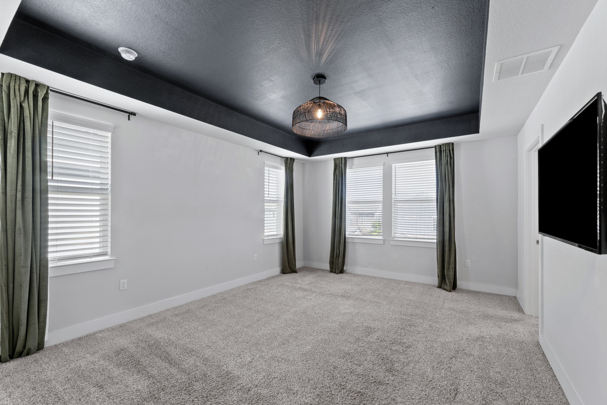 7312 Travertine Spring Drive Austin, TX 78744 - Photo 16 of 32 Recessed lighting illuminates a comfortable room, featuring soft carpeting and multiple well-lit windows.