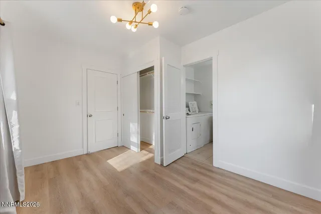 an empty room with wooden floor and ceiling fan