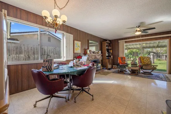 a view of a dining room with furniture a chandelier and large windows