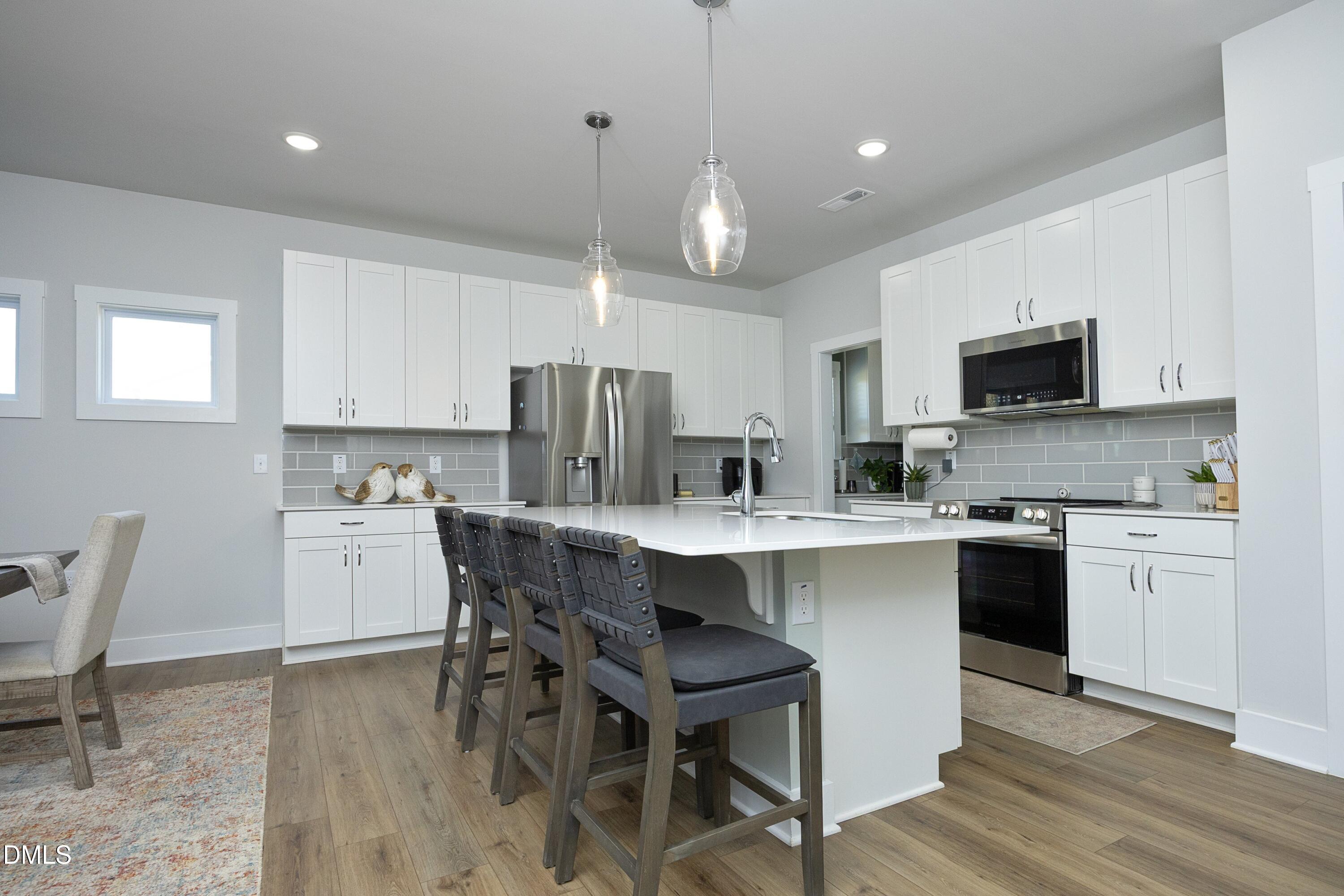 91 Kitty Br Way Clayton, NC 27520 - Photo 9 of 51 a kitchen with kitchen island granite countertop a sink a counter space stainless steel appliances and cabinets