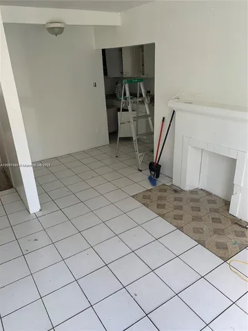 a living room with a table chairs and a stove