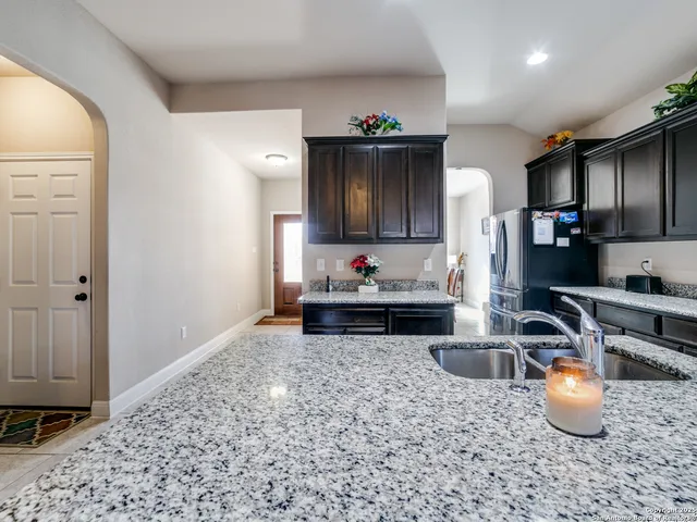 a kitchen with stainless steel appliances a sink a stove a microwave a refrigerator and cabinets