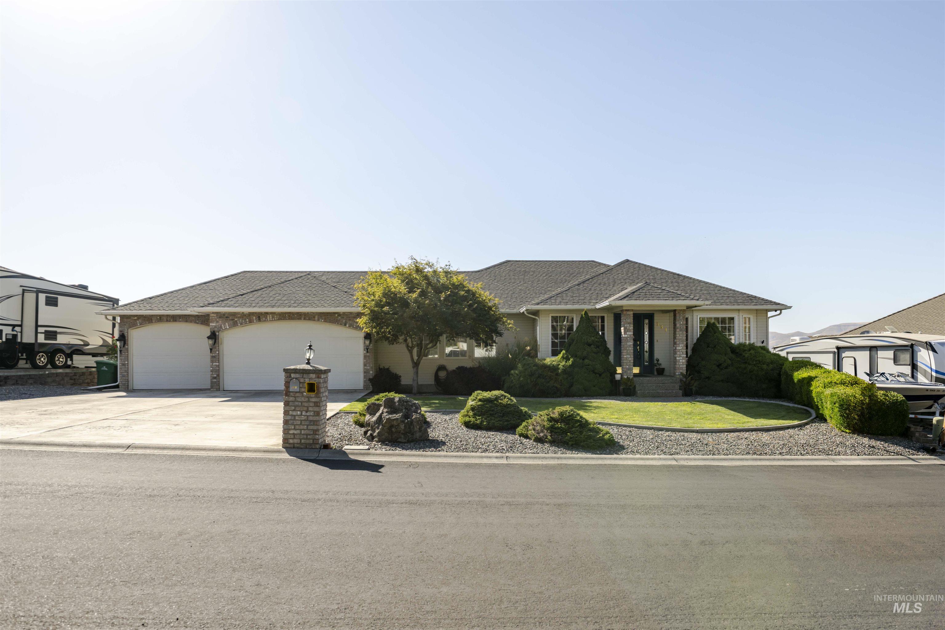 Ranch-style house with driveway, an attached garage, and roof with shingles