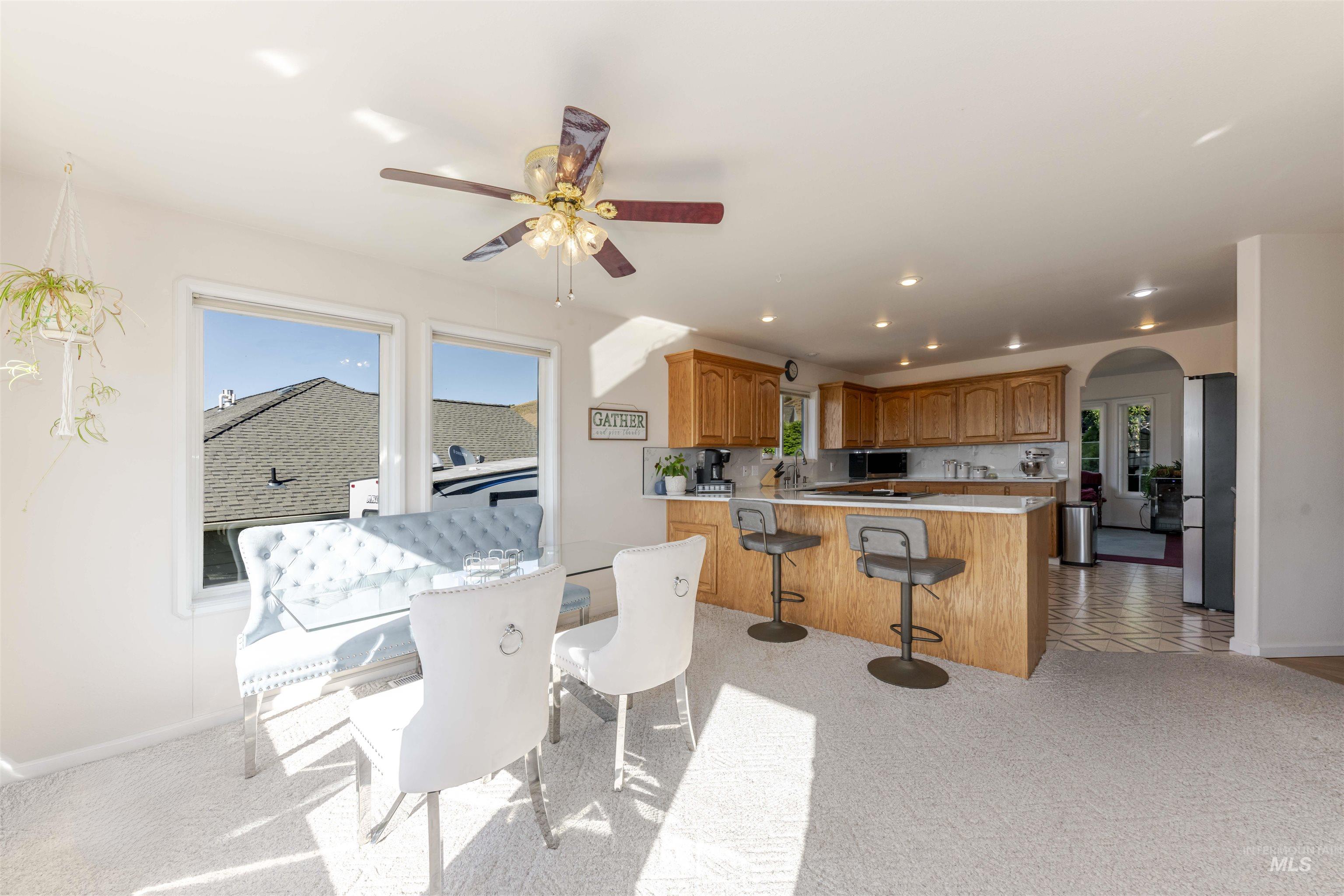 331 Reservoir Drive Lewiston, ID 83501 - Photo 12 of 42 Dining area featuring light colored carpet, arched walkways, recessed lighting, healthy amount of natural light, and a ceiling fan