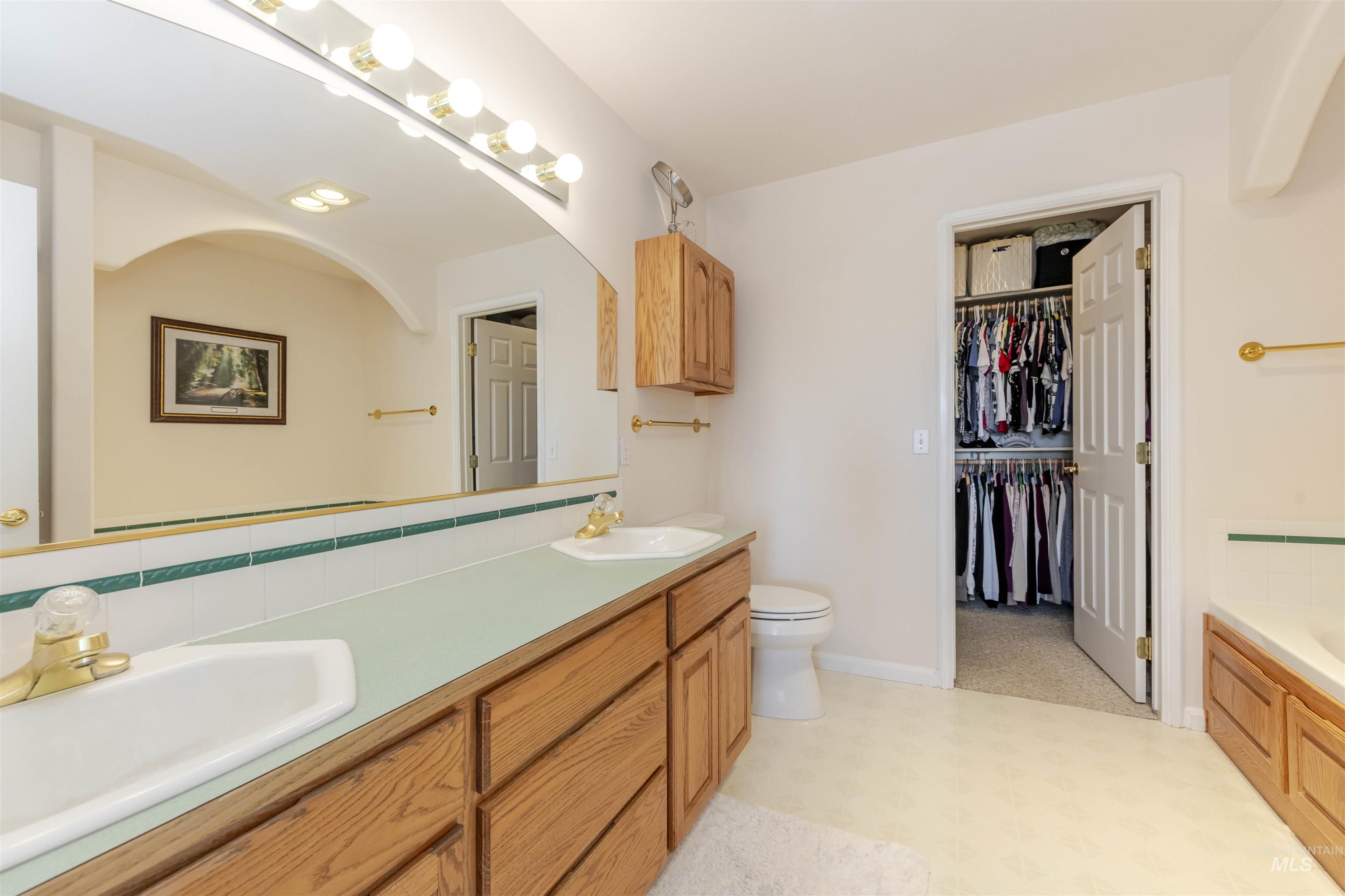 331 Reservoir Drive Lewiston, ID 83501 - Photo 21 of 42 Full bath featuring double vanity, a tub to relax in, light flooring, decorative backsplash, and a spacious closet