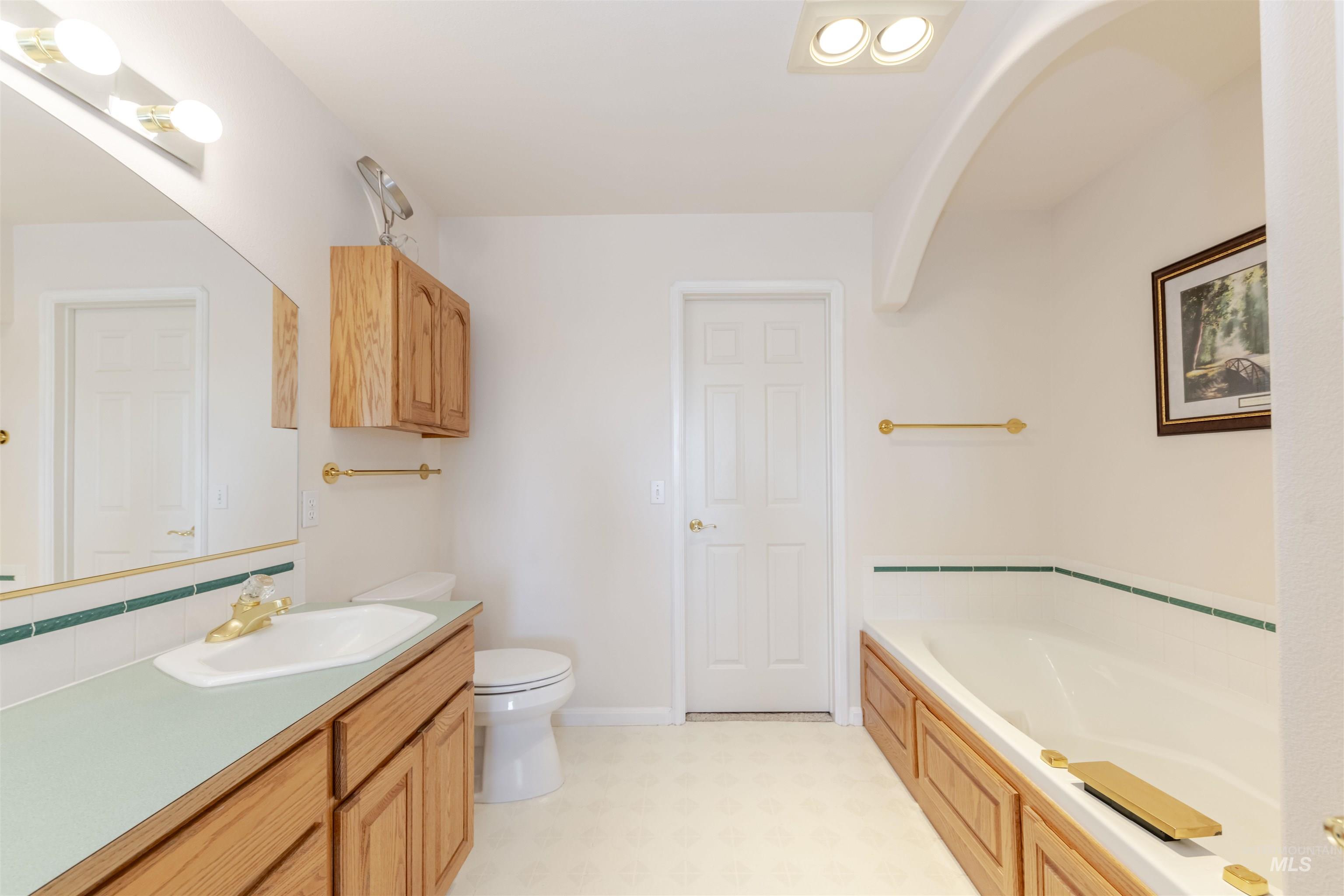 331 Reservoir Drive Lewiston, ID 83501 - Photo 23 of 42 Full bathroom featuring a garden tub, vanity, light floors, and decorative backsplash