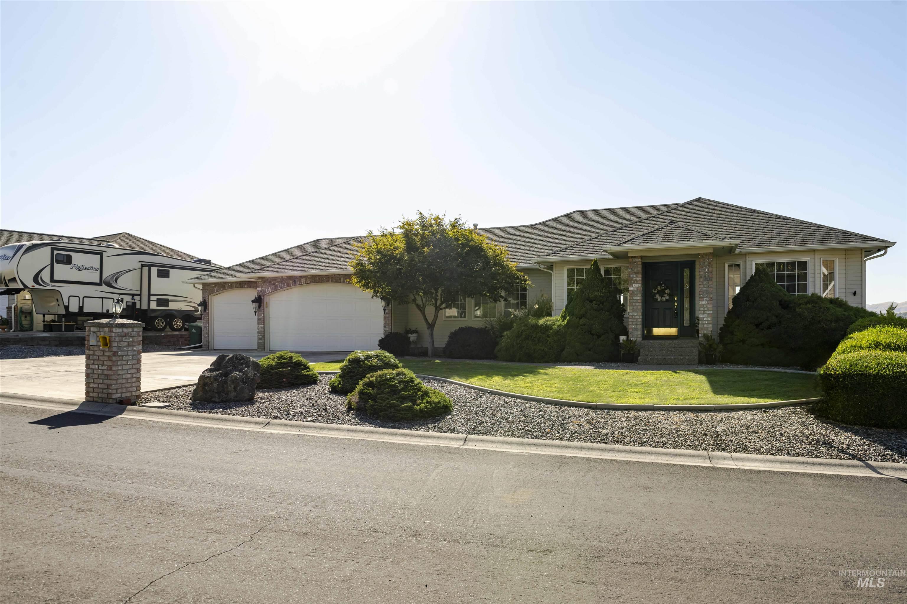 331 Reservoir Drive Lewiston, ID 83501 - Photo 42 of 42 View of front of house with concrete driveway, a garage, a front yard, brick siding, and roof with shingles