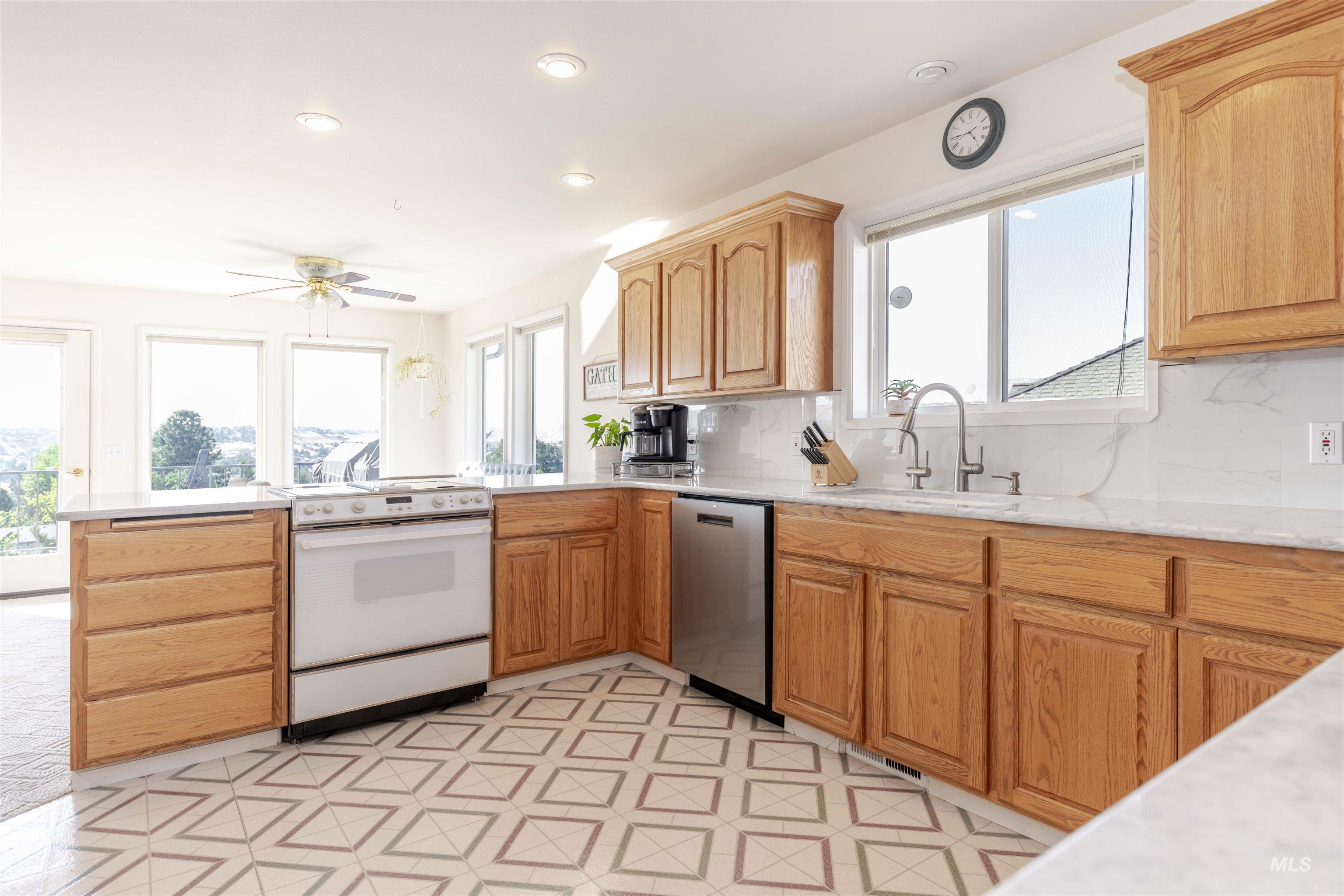 331 Reservoir Drive Lewiston, ID 83501 - Photo 6 of 42 Kitchen featuring electric stove, a peninsula, dishwasher, ceiling fan, and tasteful backsplash