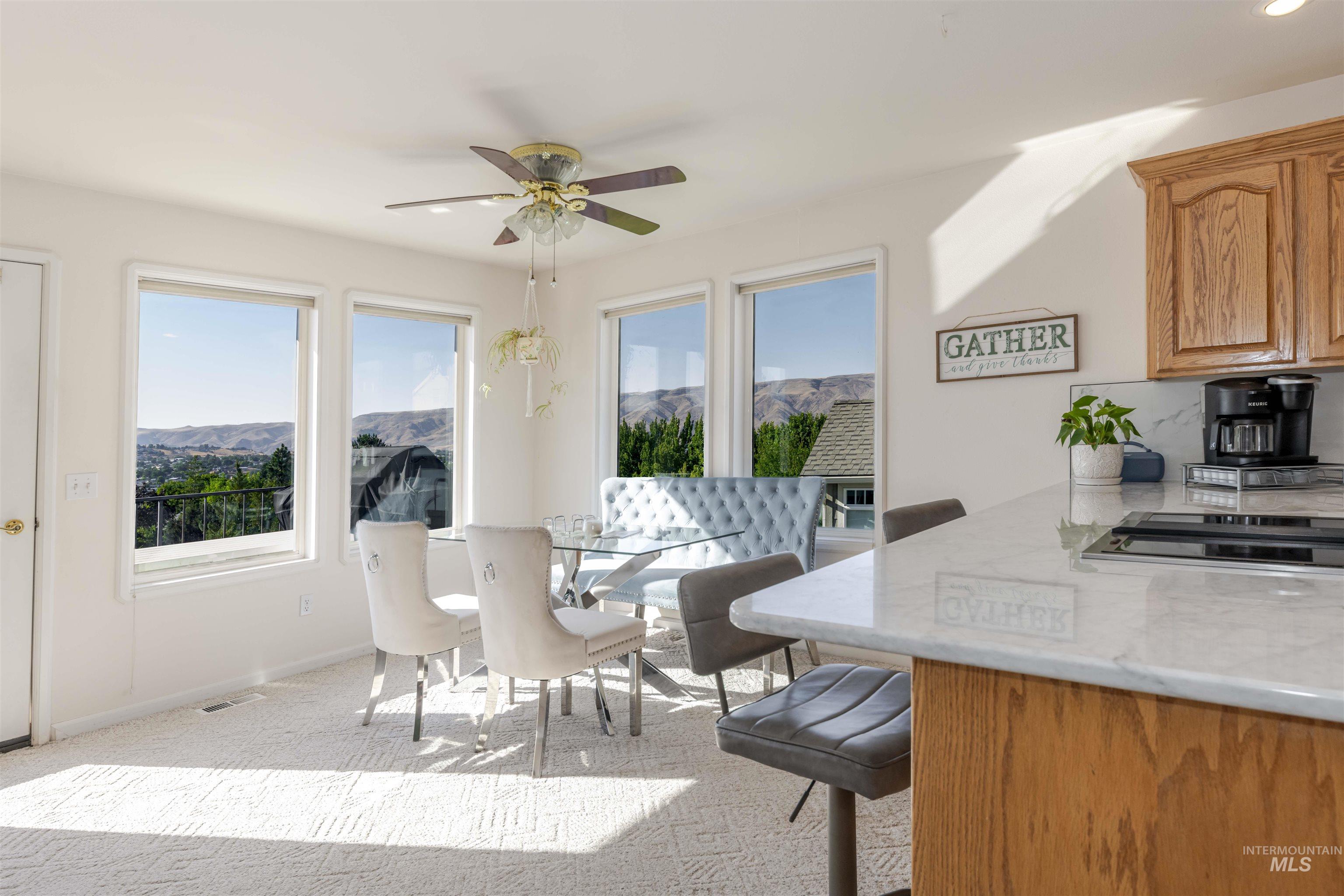 331 Reservoir Drive Lewiston, ID 83501 - Photo 10 of 42 Dining room featuring a mountain view, light carpet, and a ceiling fan