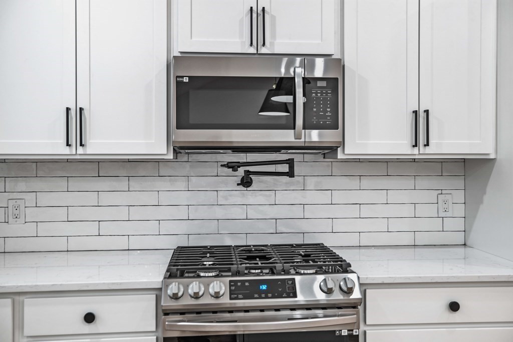 216 Grove Street Randolph, MA 02368 - Photo 13 of 34 a stove top oven sitting inside of a kitchen