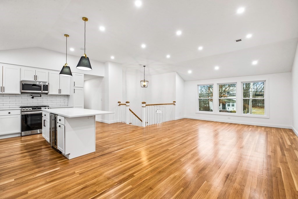 216 Grove Street Randolph, MA 02368 - Photo 2 of 34 a large kitchen with stainless steel appliances granite countertop a sink a stove and a wooden floors