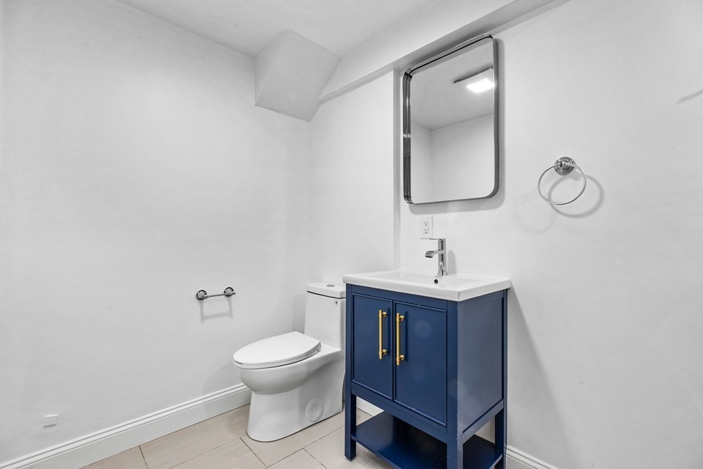 216 Grove Street Randolph, MA 02368 - Photo 27 of 34 a bathroom with a toilet a sink and mirror