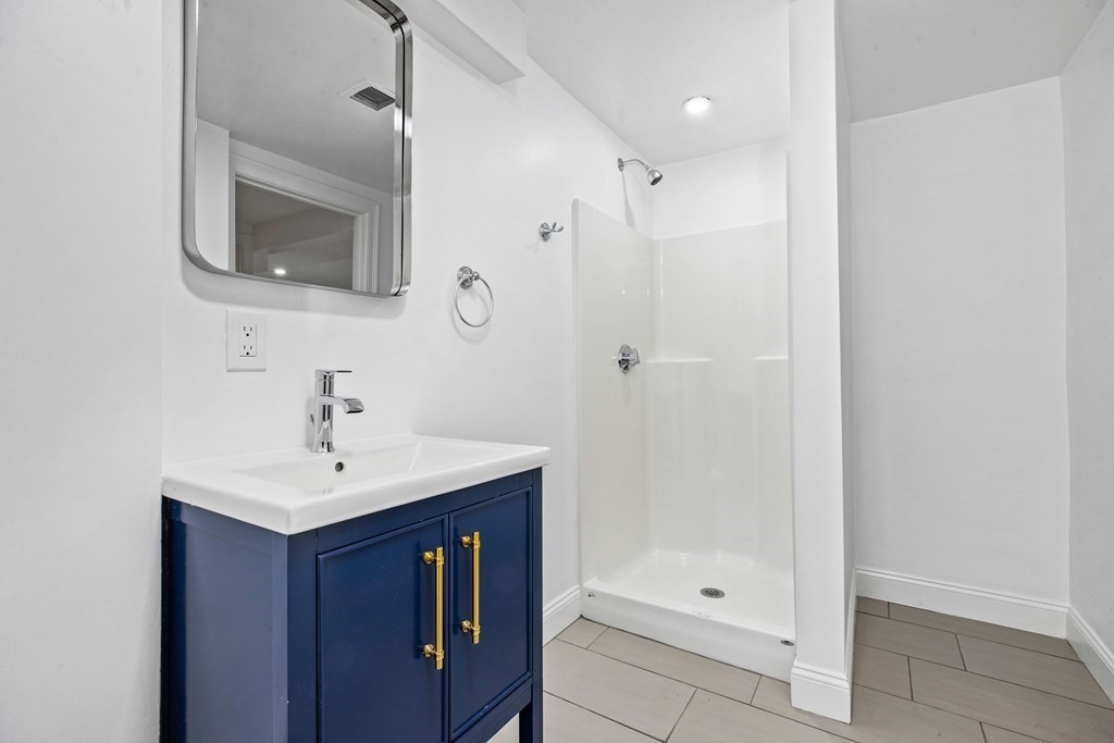 216 Grove Street Randolph, MA 02368 - Photo 28 of 34 a bathroom with a sink a mirror and shower