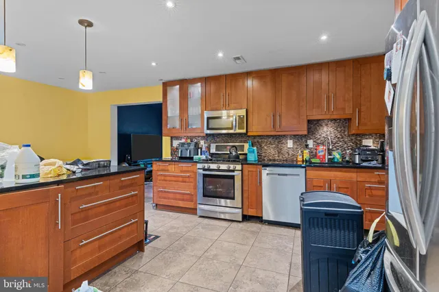 a kitchen with stainless steel appliances granite countertop wooden cabinets a stove top oven a sink and dishwasher