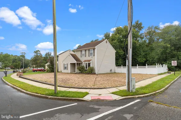 a view of a house with a big yard and palm trees