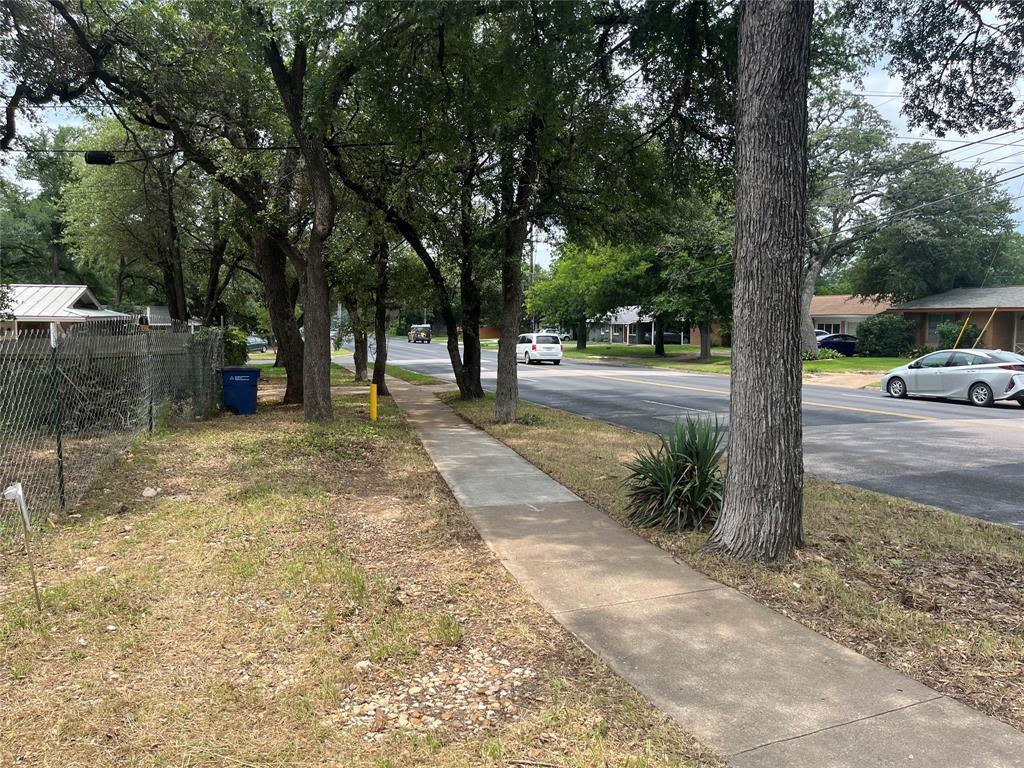 4621 Menchaca Road Austin, TX 78745 - Photo 2 of 7 a view of a street with trees on both side of it