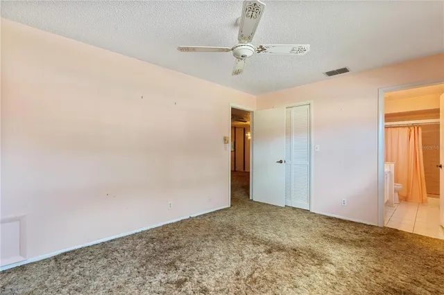 a view of a big room with wooden floor and chandelier fan