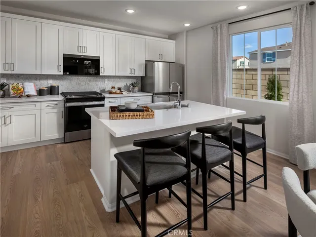 a kitchen with a stove a sink a microwave and cabinets
