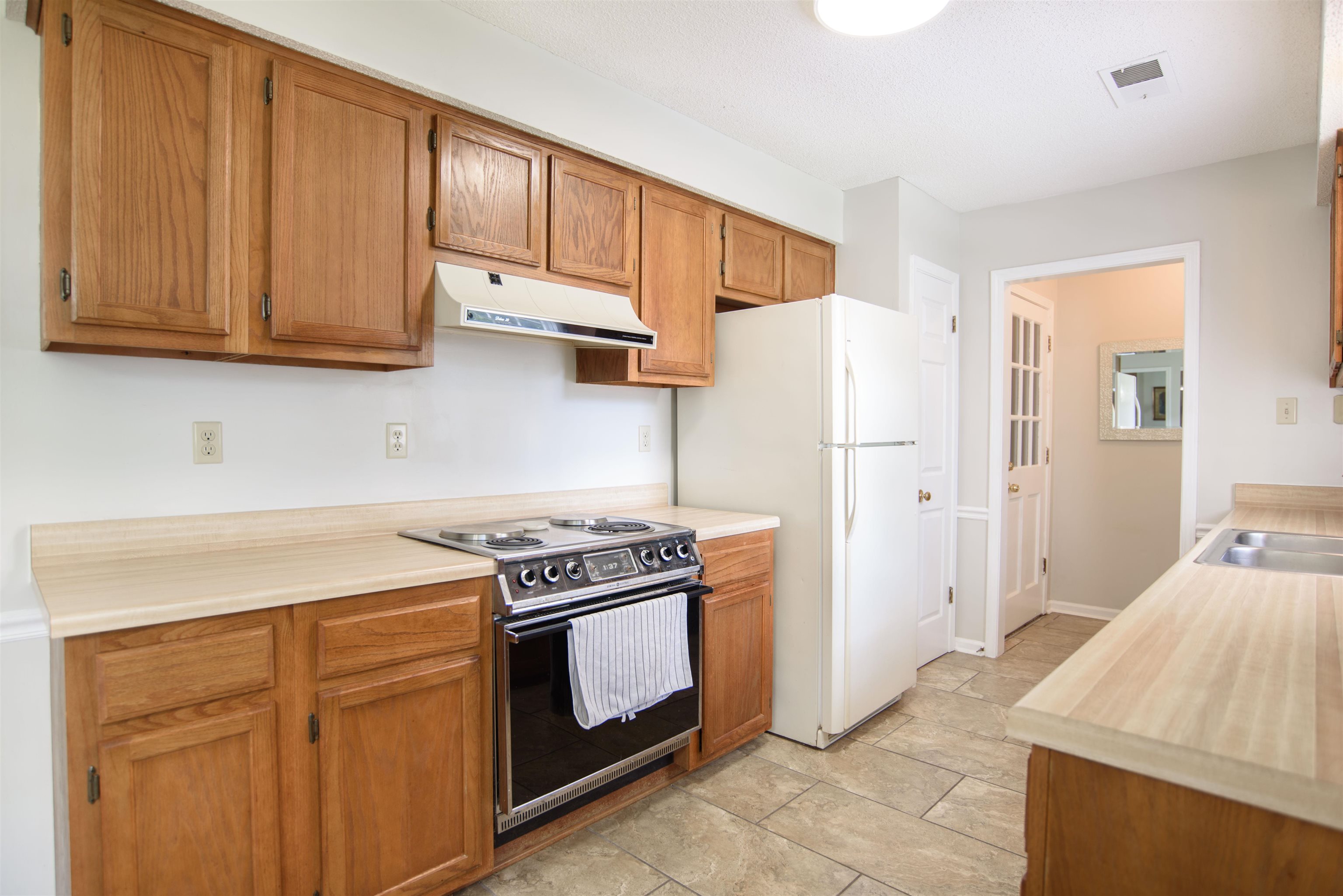 377 Great Falls Road Collierville, TN 38017 - Photo 8 of 16 a kitchen with wooden cabinets and a stove top oven