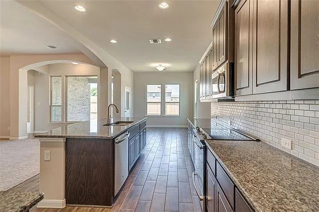 20008 Navarre Terrace Pflugerville, TX 78660 - Photo 3 of 18 a kitchen with granite countertop a stove and a sink